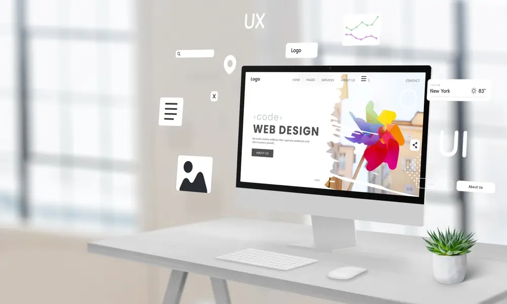 Computer display on a work desk featuring a web design studio page